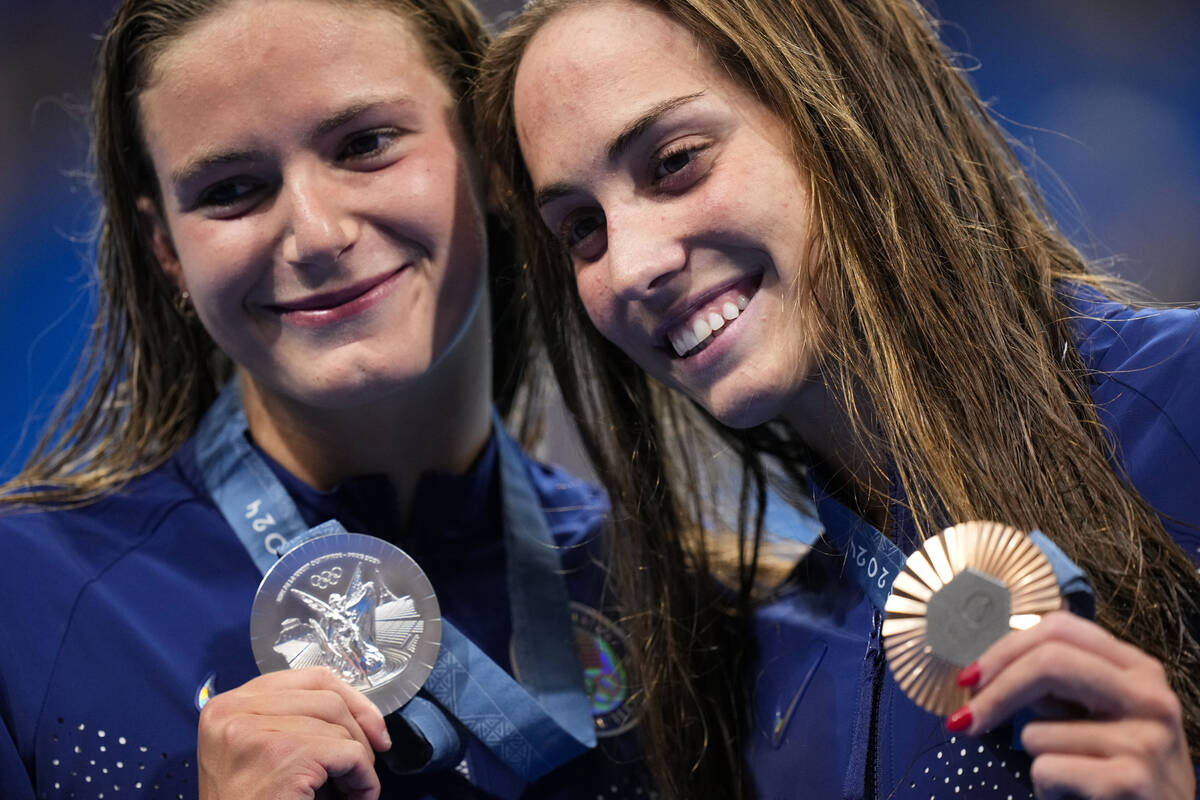 Silver medalist, Katie Grimes, left, of the United States, left, stands with compatriot and bro ...