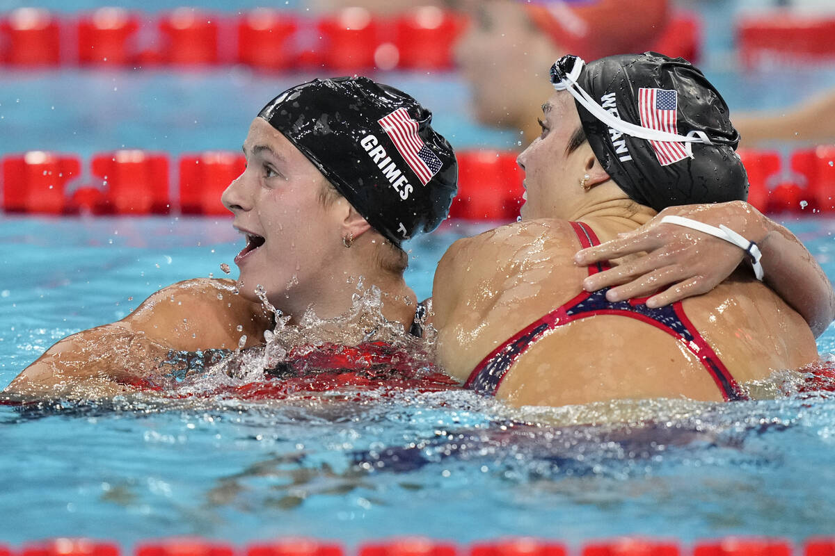 Katie Grimes, left, of the United States embraces compatriot Emma Weyant, after the women's 400 ...