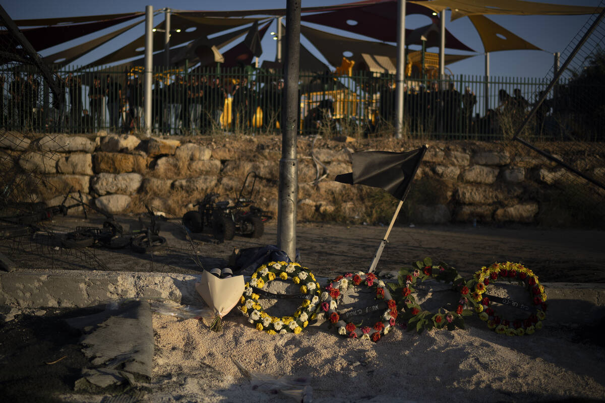 Wreath of flowers are placed on the site of a rocket's strike killing children and teens at a s ...