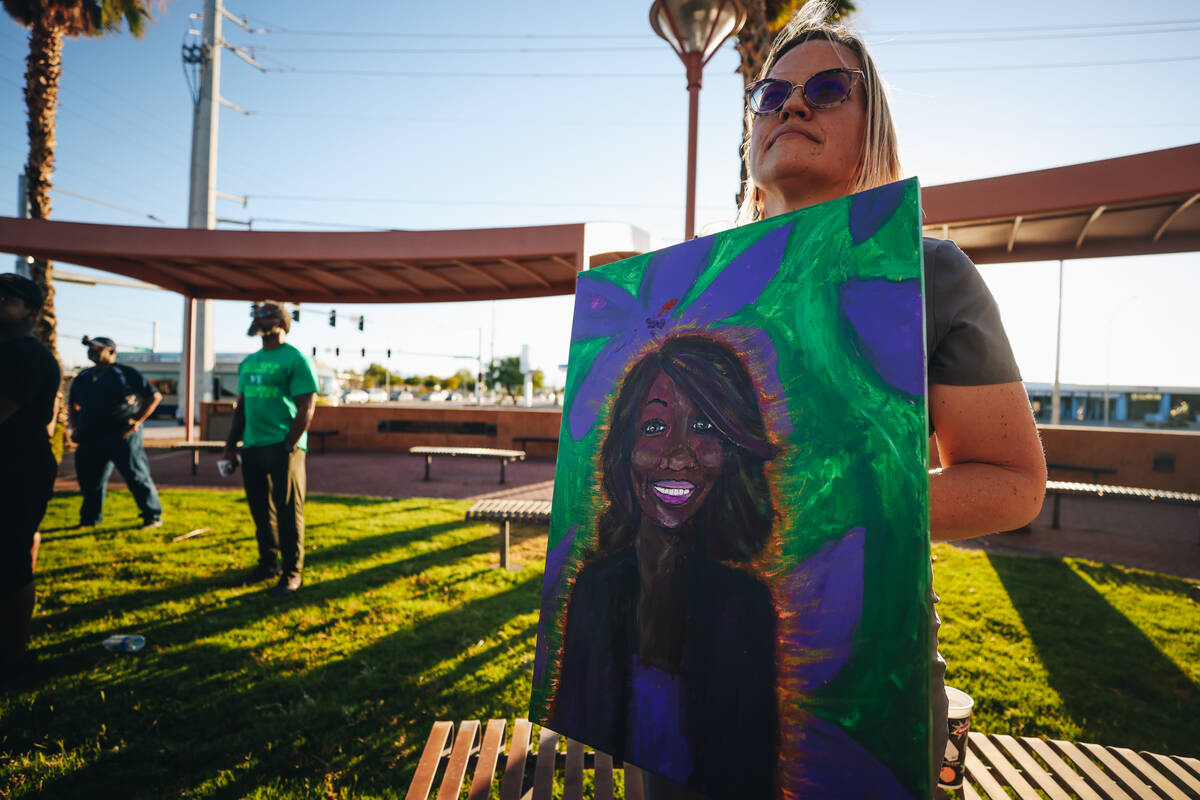 A mourner holds a painting of Sonya Massey during a vigil for Sonya Massey, a Black woman who w ...