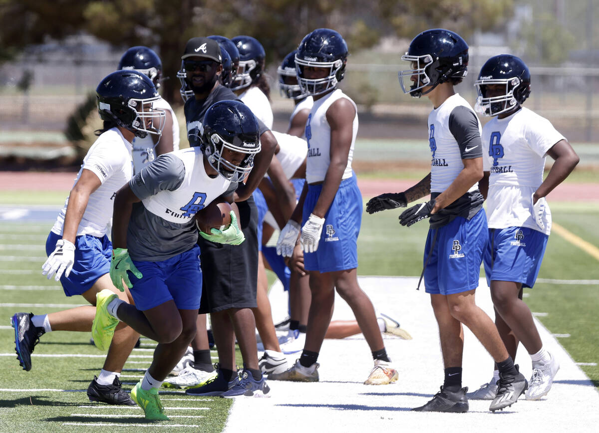 Desert Pines wide receiver Jahmih Harrison goes out of bound after catching the ball during the ...