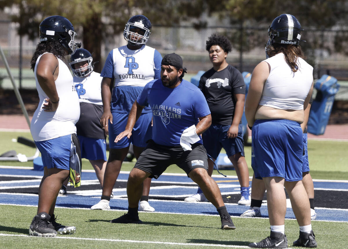 Desert Pines players watch as head coach Jose Flores demonstrates defensive drills during the f ...