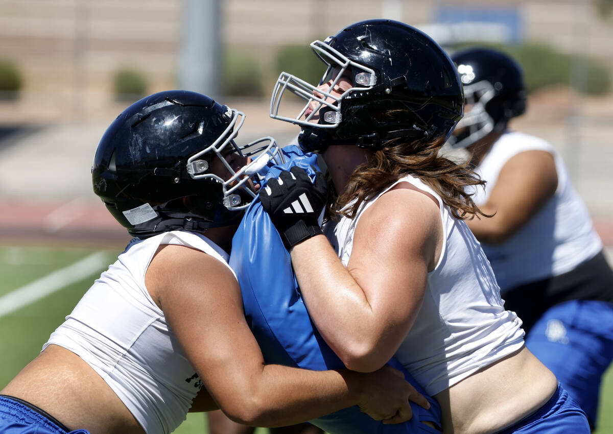 Desert Pines offensive lines Aron Villanova, left, and Gabriel Gough run a blocking drill duri ...