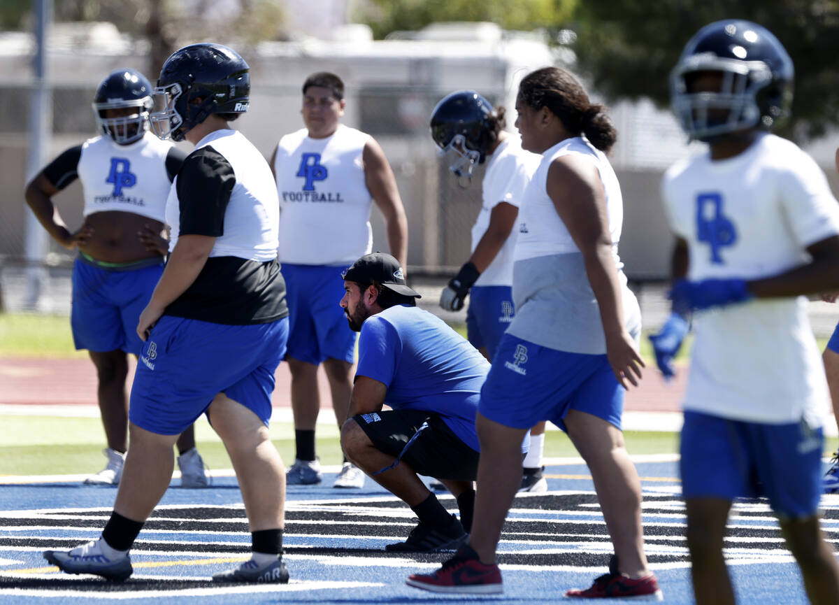 Desert Pines head coach Jose Flores, center, watches as players take the field to participate i ...