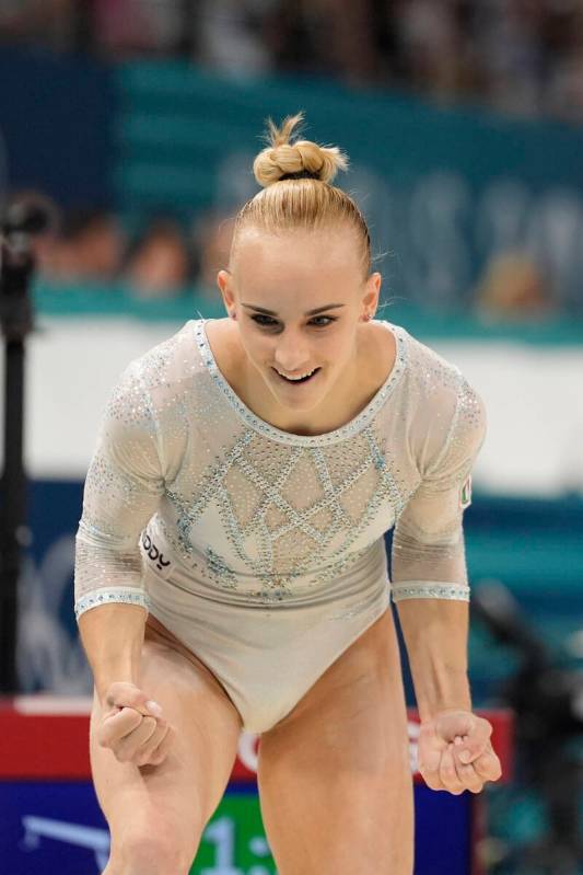 Alice D'Amato, of Italy, celebrates after performing on the balance beam during the women's art ...