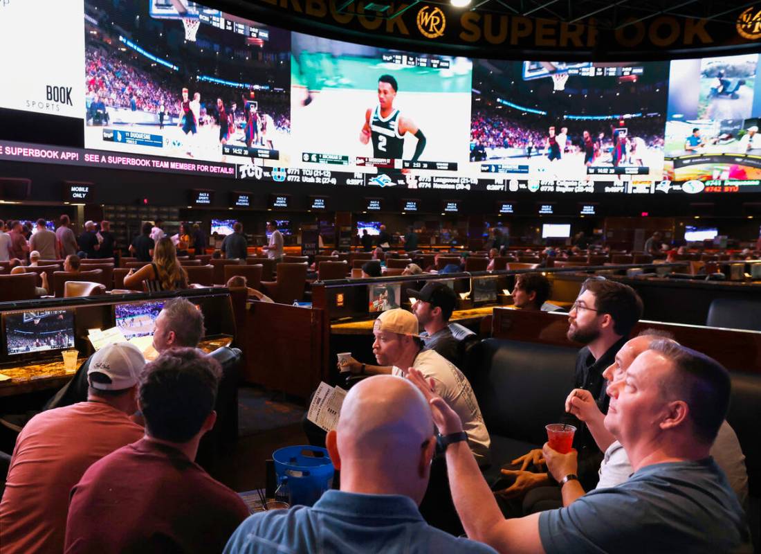 Guests watch on the big screens the first day of the NCAA basketball tournament at Westgate spo ...