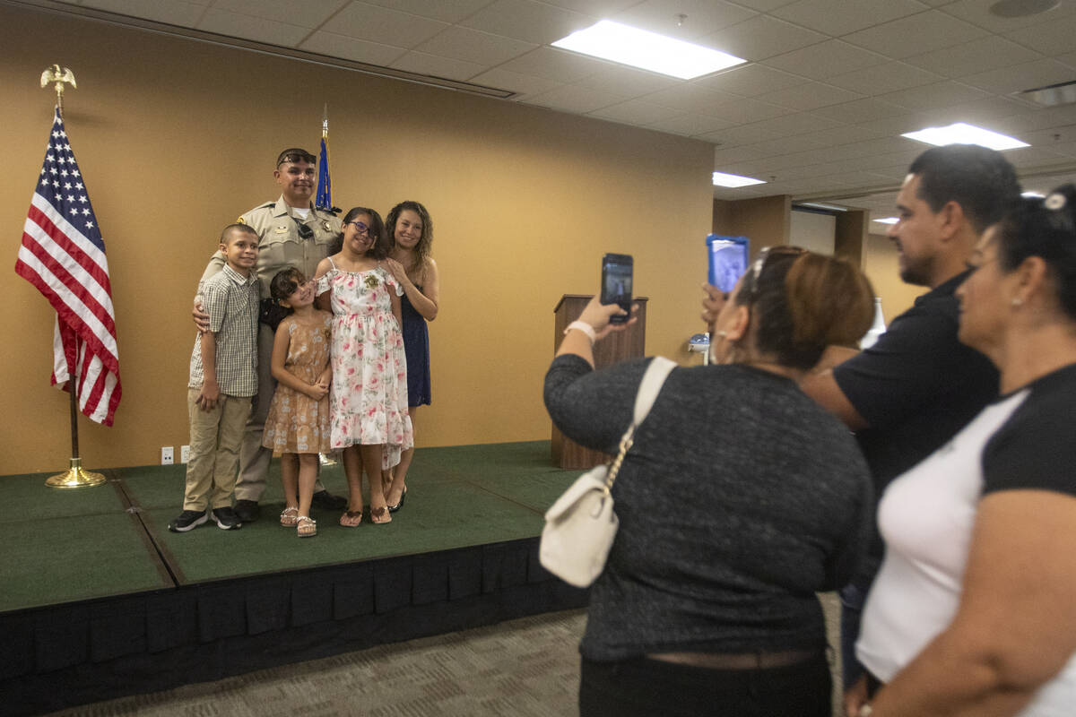 Officer Antonio Valencia-Barajas takes photographs with family and friends after receiving an a ...