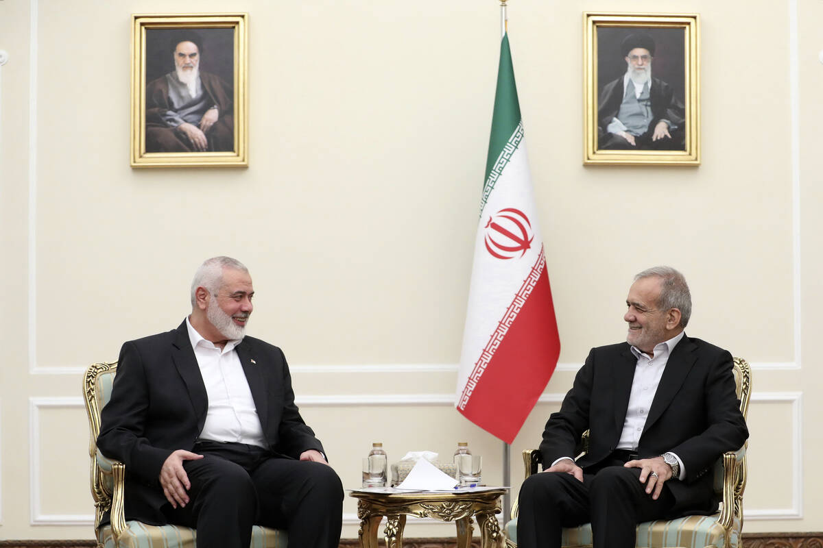 In this photo released by the Iranian Presidency Office, President Masoud Pezeshkian, right, me ...