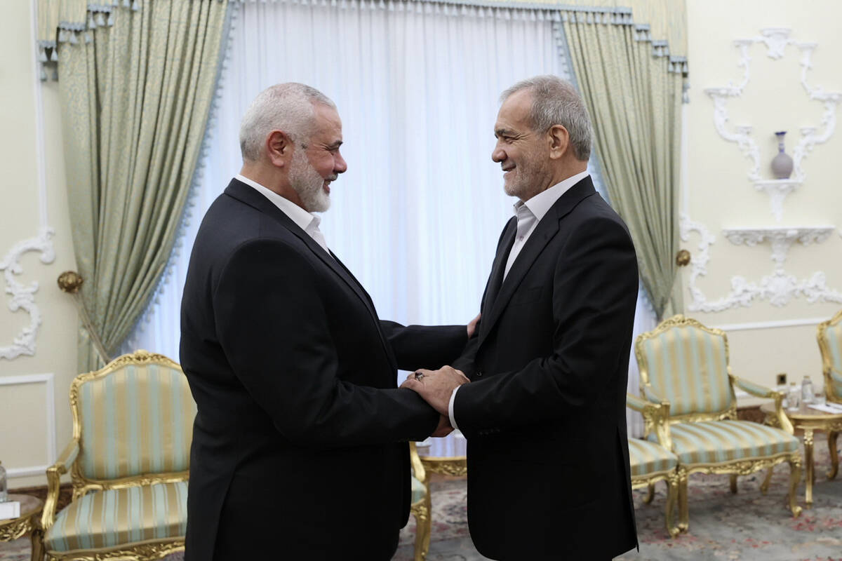 In this photo released by the Iranian Presidency Office, President Masoud Pezeshkian, right, sh ...