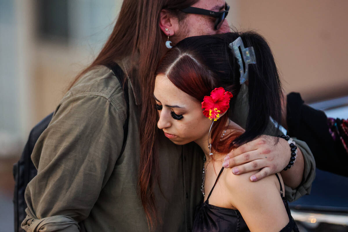 Mourners embrace during a vigil for Kameron Moore and Vincent Herrera at the Riverbend Village ...