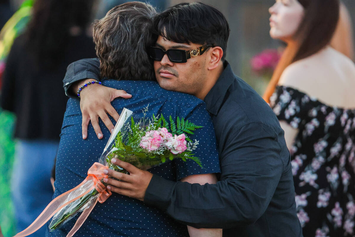 Mourners embrace during a vigil for Kameron Moore and Vincent Herrera at the Riverbend Village ...