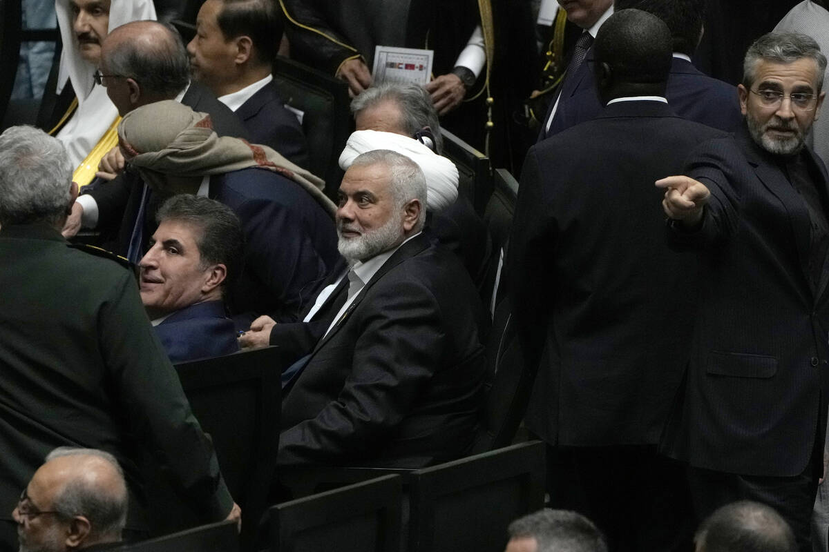 Hamas chief Ismail Haniyeh, center, sits prior to the start of the swearing-in ceremony of newl ...