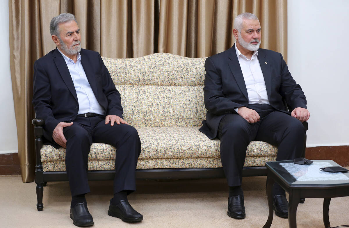 In this photo released by the office of the Iranian supreme leader, Hamas chief Ismail Haniyeh, ...