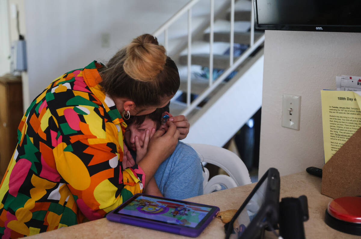 Heidi Tunea puts earplugs on her son Jakob Velez, 8, to calm him down from being overstimulated ...