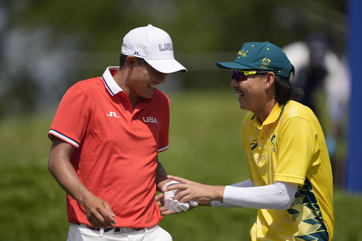 Collin Morikawa, of the United States, left, speaks to Min Woo Lee, of Australia, on the 14th f ...