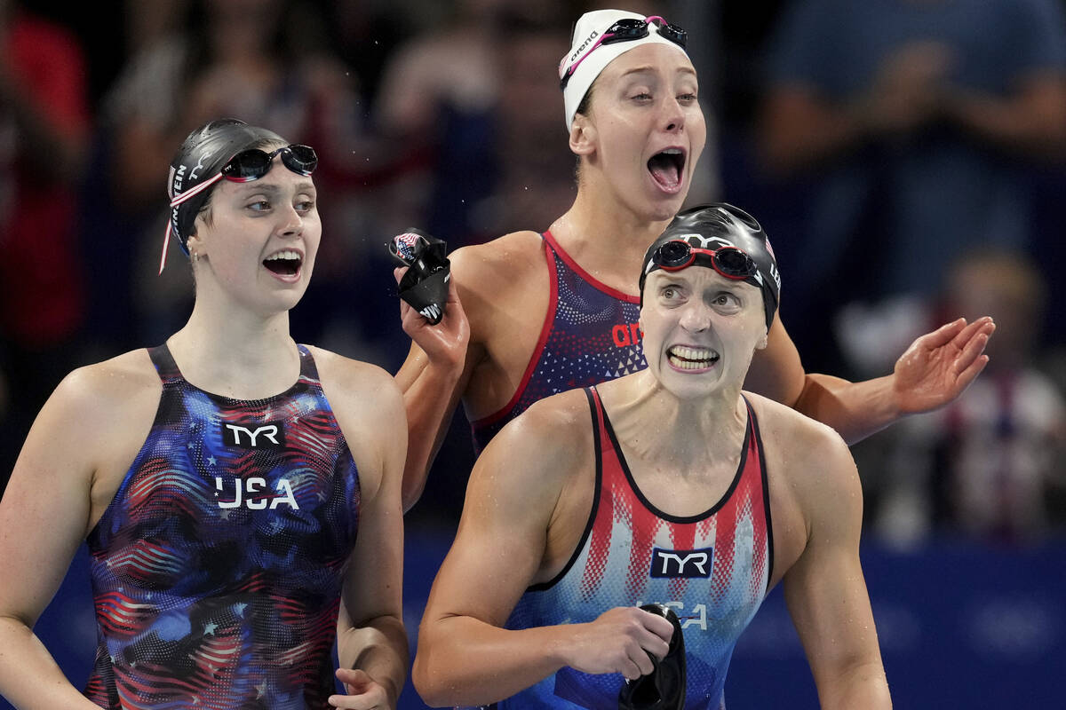 United States' Claire Weinstein, left, Katie Ledecky, right, and Paige Madden, rear, react as t ...