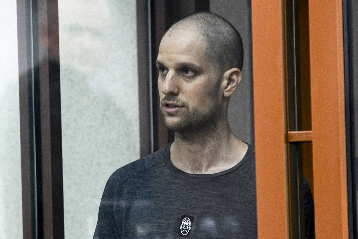 FILE - Wall Street Journal reporter Evan Gershkovich stands listening to the verdict in a glass ...