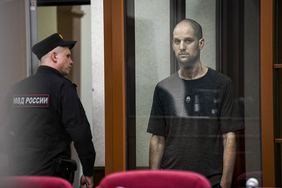 Wall Street Journal reporter Evan Gershkovich stands listening to the verdict in a glass cage o ...