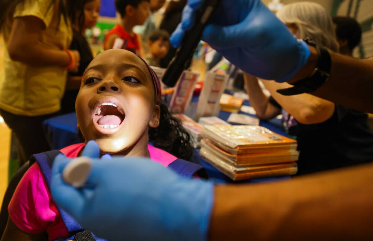 Tenaya Jordan, 10, gets a free dental check during a back to school fair at Rancho High School ...