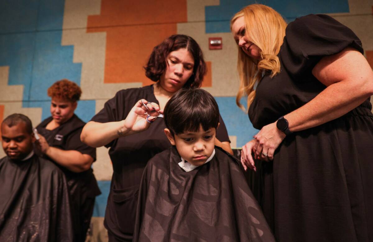 Israel Jimenez, 5, gets his hair trimmed during a back to school fair at Rancho High School on ...