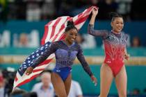 Simone Biles, left, celebrates with teammate Suni Lee, of the United States, after winning the ...