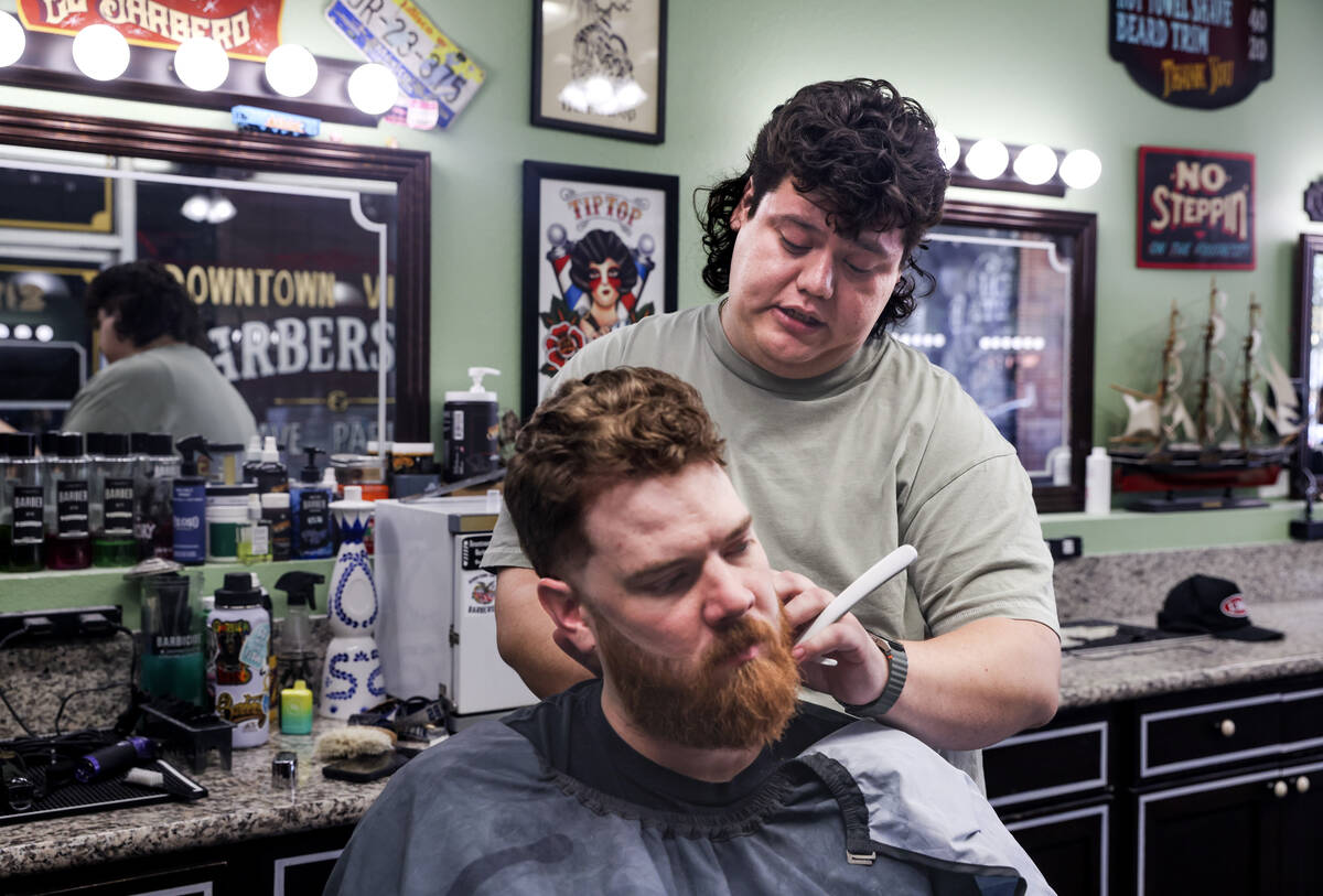 Cesar Reyes, barber and manager, cuts the hair of fellow barber John Hasler at Downtown Vintage ...