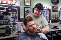 Cesar Reyes, barber and manager, cuts the hair of fellow barber John Hasler at Downtown Vintage ...