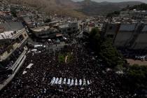 FILE - Mourners from the Druze minority surround the bodies of some of the 12 children and teen ...