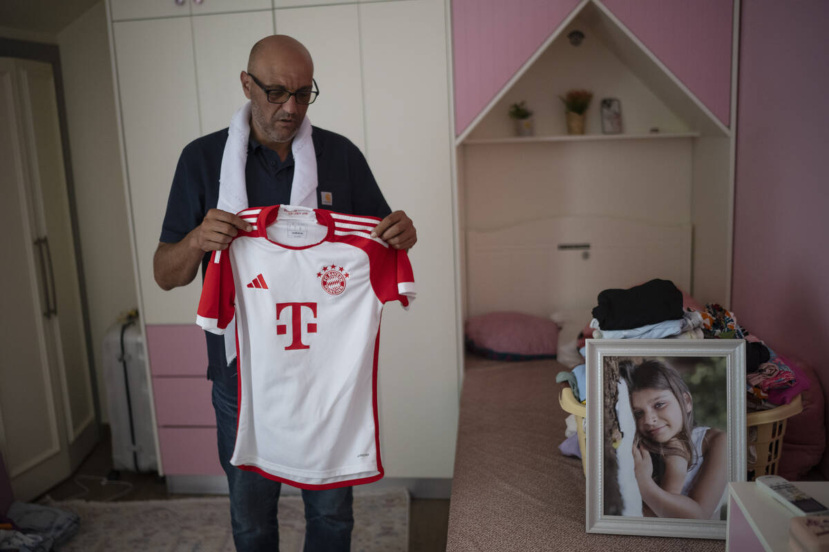 Alma's father, Ayman Fakhr al-Din, shows one her favourite soccer jerseys, as he stands in his ...