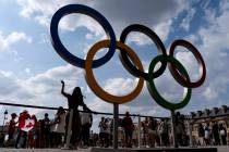 The public lines up to have their picture taken with the Olympic rings in front of the Louvre m ...