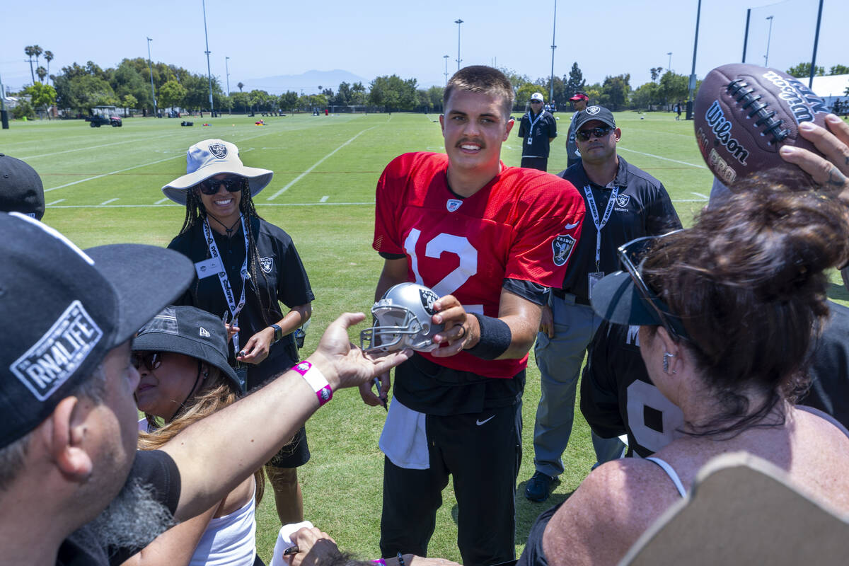 Raiders quarterback Aidan O'Connell (12) signs autographs for fans following the third day of t ...