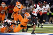 Bishop Gorman defensive back Jett Washington (5) hangs on to bring down Centennial running back ...