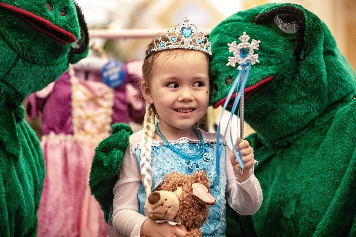 Samantha Buckley, 5, takes a photograph with royal frogs during a Make-A-Wish Southern Nevada t ...