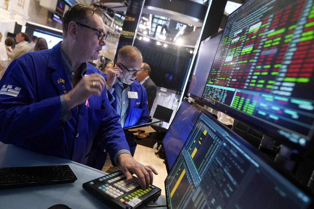 Specialist Patrick King, left, works at his post on the floor of the New York Stock Exchange, T ...