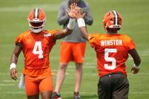 Cleveland Browns quarterbacks Deshaun Watson (4) and Jameis Winston (5) high-five during an NFL ...