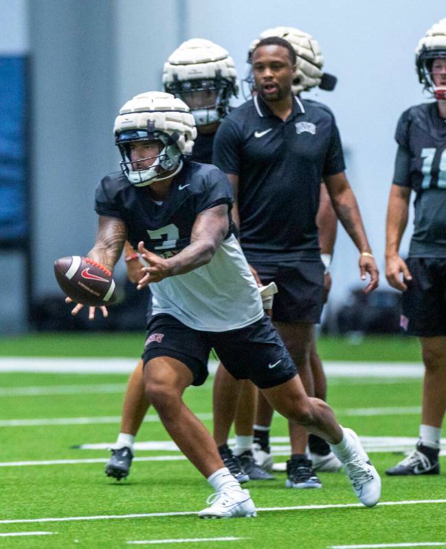 UNLV quarterback Cameron Friel (7) tosses the ball to a running back during football practice a ...