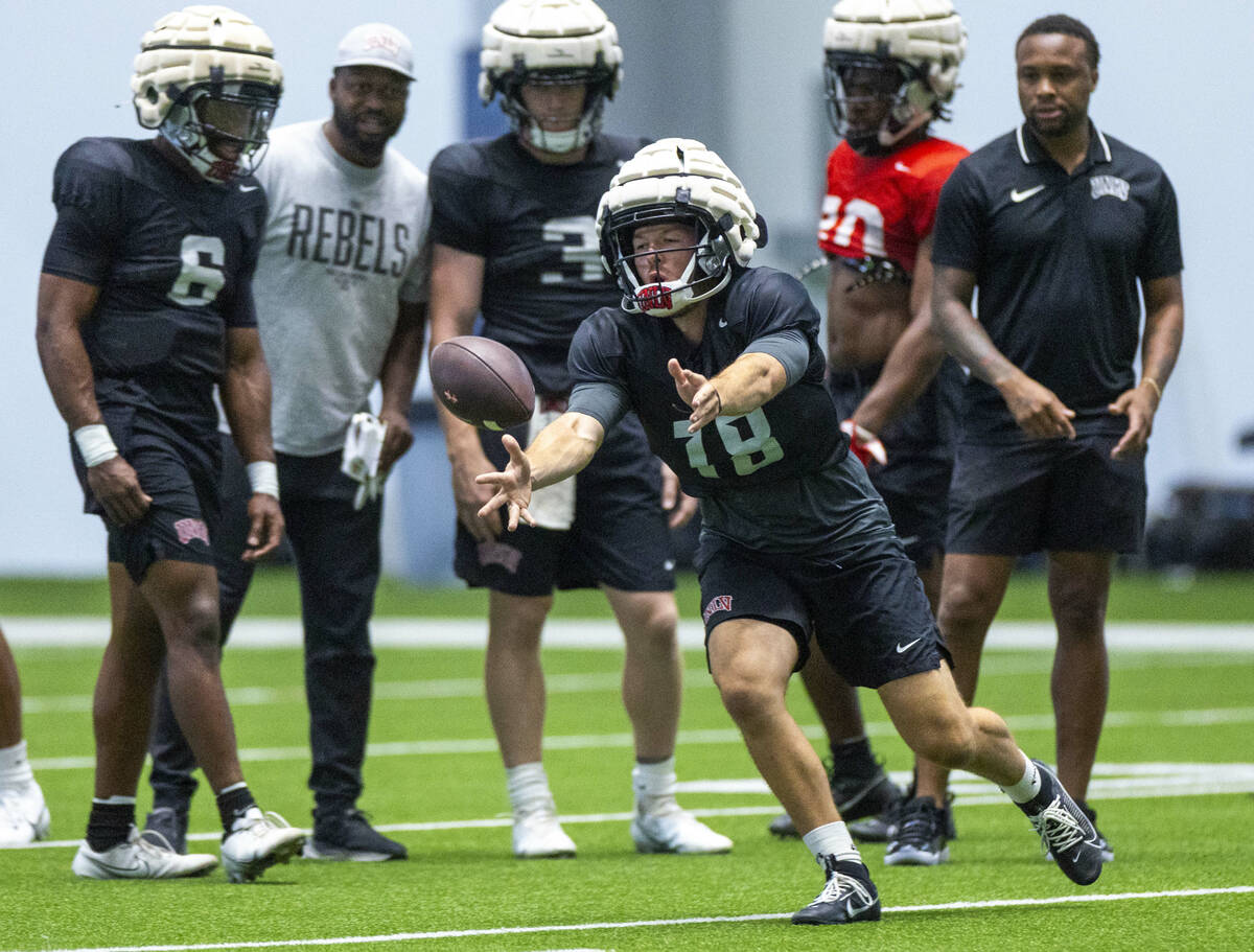 UNLV quarterback Lucas Lenhoff (18) tosses the ball to a running back during football practice ...