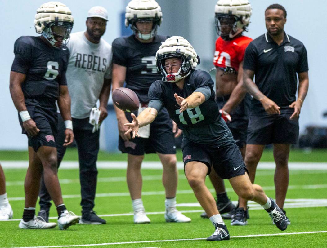 UNLV quarterback Lucas Lenhoff (18) tosses the ball to a running back during football practice ...