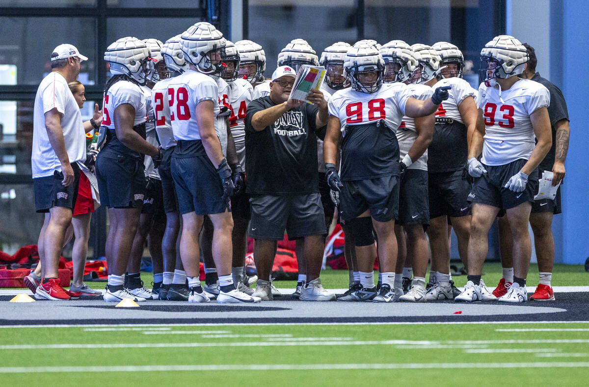 UNLV defensive line coach Ricky Logo works with his players during football practice at the Int ...