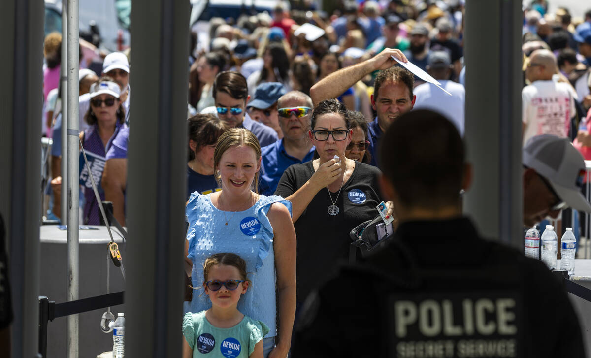 Attendees line up in the sun to be screened for entry as Vice President Kamala Harris and her r ...