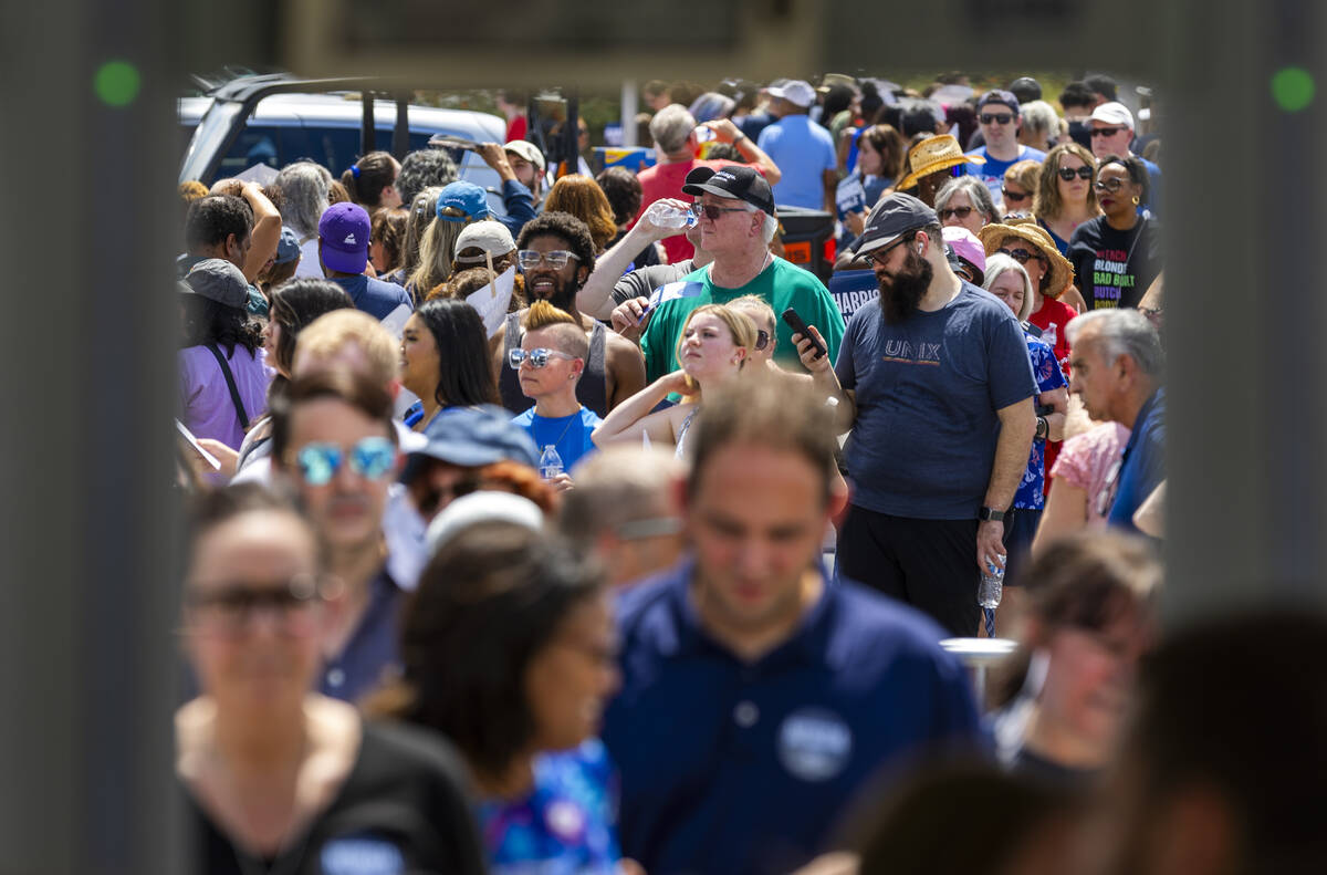 Attendees line up in the sun to be screened for entry as Vice President Kamala Harris and her r ...