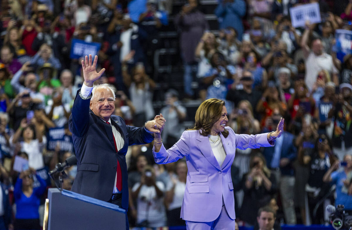 Minnesota Gov. Tim Walz greets Vice President Kamala Harris as she arrives on stage during a ca ...