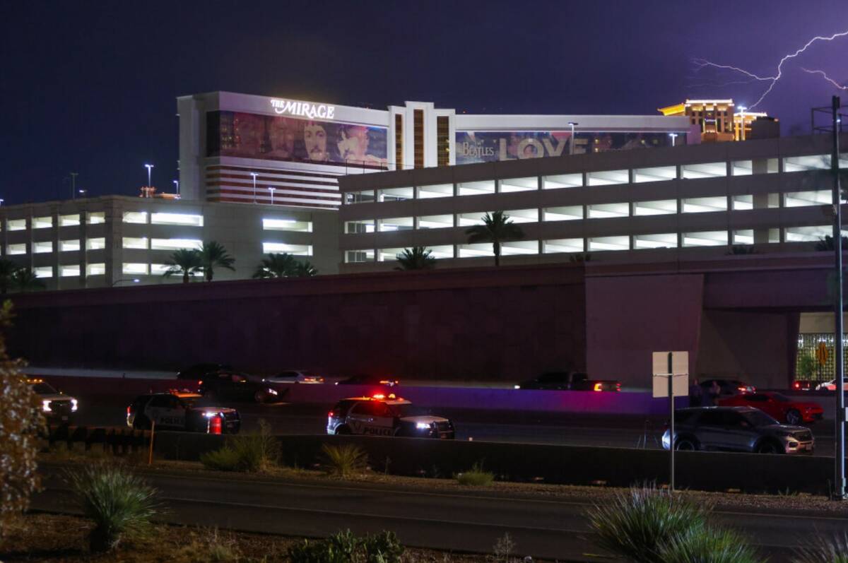 Lightning flashes over the Strip as police investigate a shooting on Interstate 15 southbound o ...