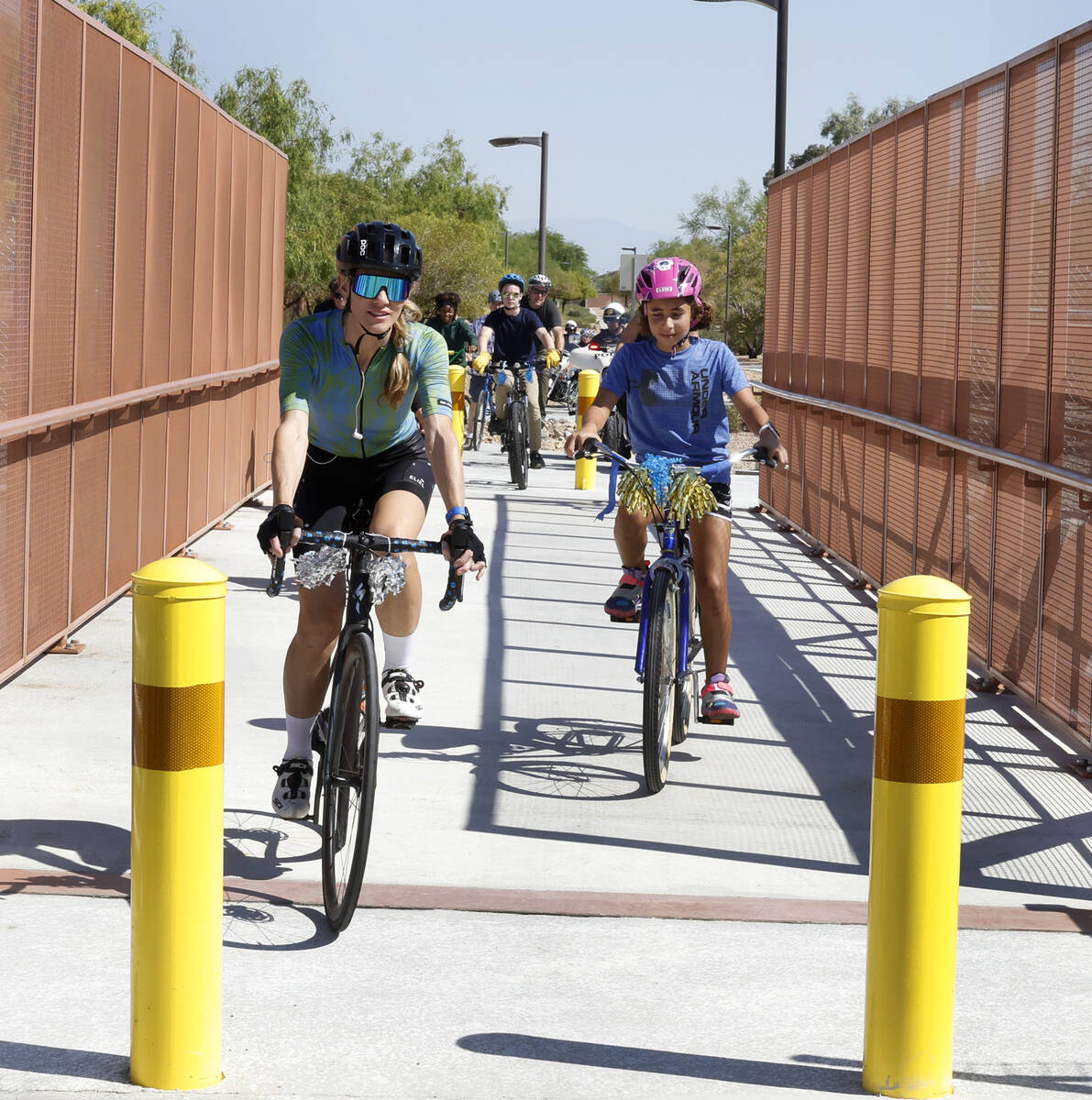 Riders cross the new pedestrian and bicycle bridge near Gunderson Middle School after a ribbon ...