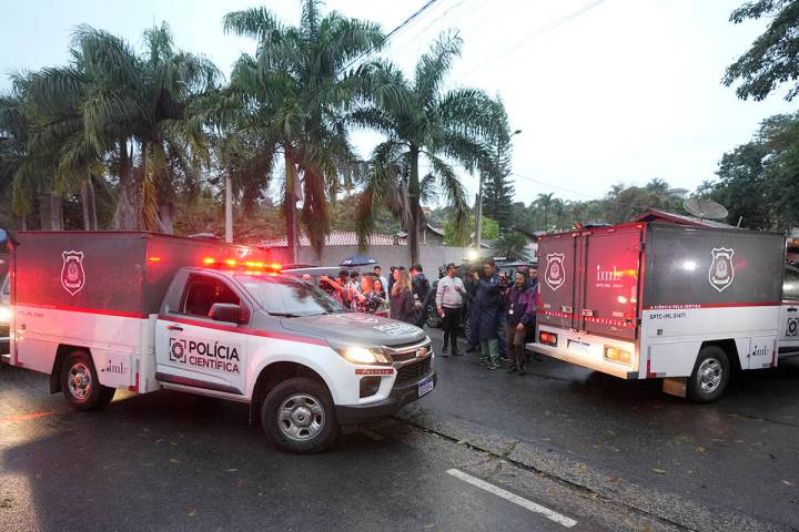 Police vehicles used to carry bodies arrive at the gated community where a plane crashed in Vin ...