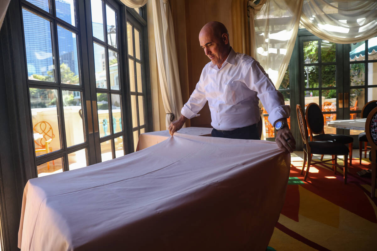 Server Robert Capblancq prepares a table for dinner service at Picasso at the Bellagio hotel-ca ...