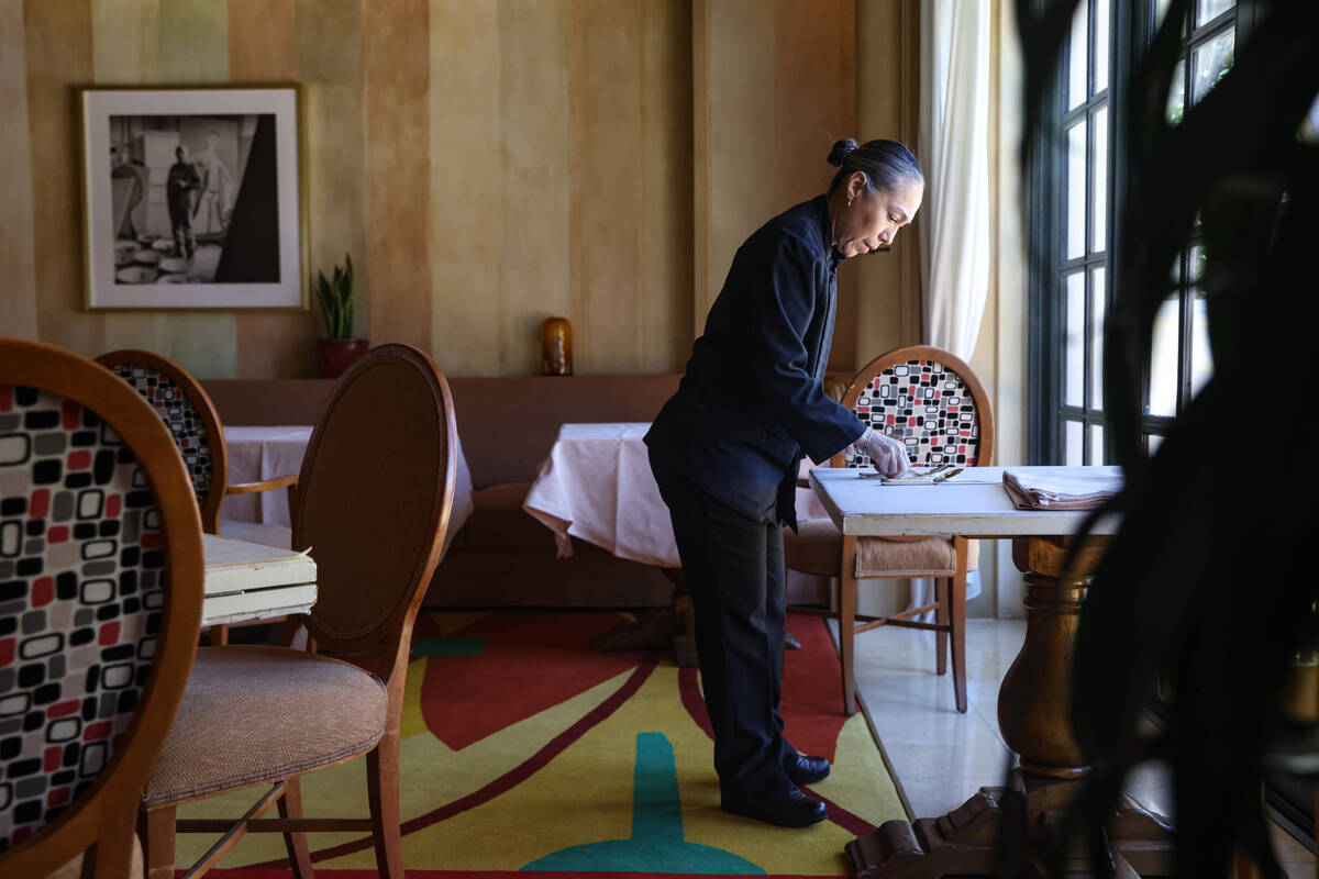 Busser Brenda Sanchez prepares a table for dinner service at Picasso at the Bellagio hotel-casi ...