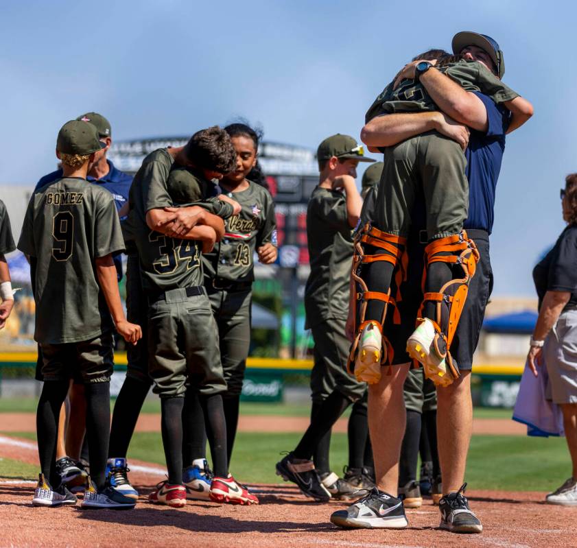 Nevada manager Adam Johnson hugs catcher Parker Soranaka (23) as they celebrate their 2-0 win o ...