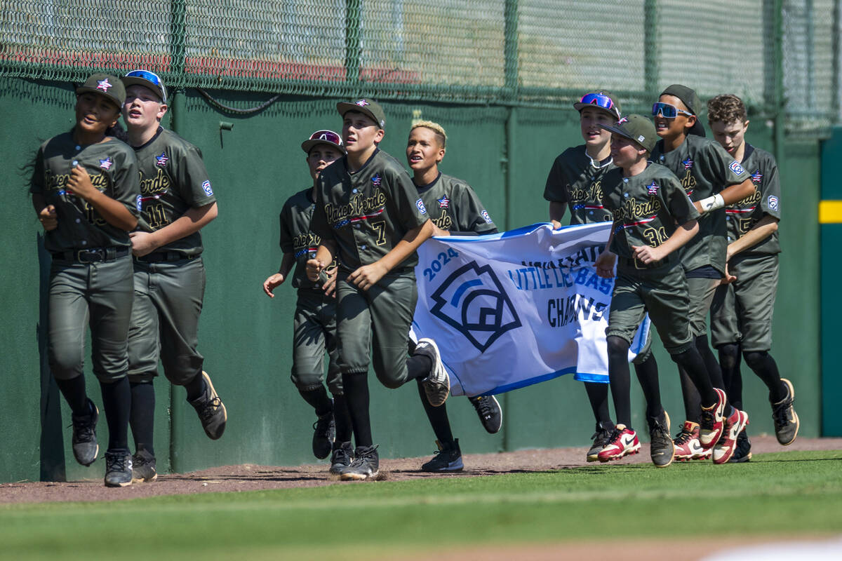 Nevada players run the field with their winning banner after defeating Utah 2-0 in the Mountain ...