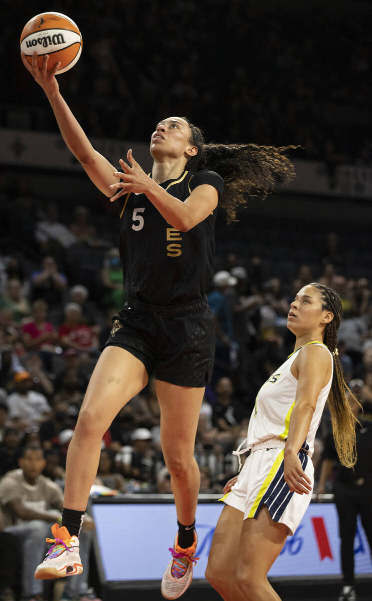 Aces forward Dearica Hamby (5) drives past Dallas Wings guard Veronica Burton (12) in the first ...